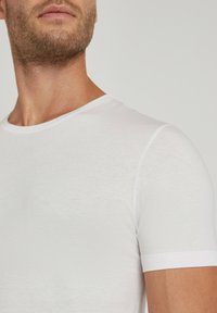 White short-sleeve t-shirt made of soft, lightweight fabric. Features a classic round neck and smooth texture, with minimal stitching detail.