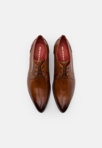 Zapatos de vestir de cuero marrón con punta afilada, diseño de cordones y textura suave. El interior cuenta con un forro rojo con un logotipo.