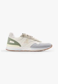 Zapatilla baja con paneles de ante beige, gris y verde, logo de calavera y huesos cruzados en el lateral, media suela blanca texturizada y suela de goma marrón.