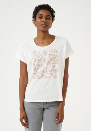 T-shirt blanc à manches courtes avec un col rond, présentant un design paisley doré rose métallique sur le devant. Tissu en coton, texture douce.