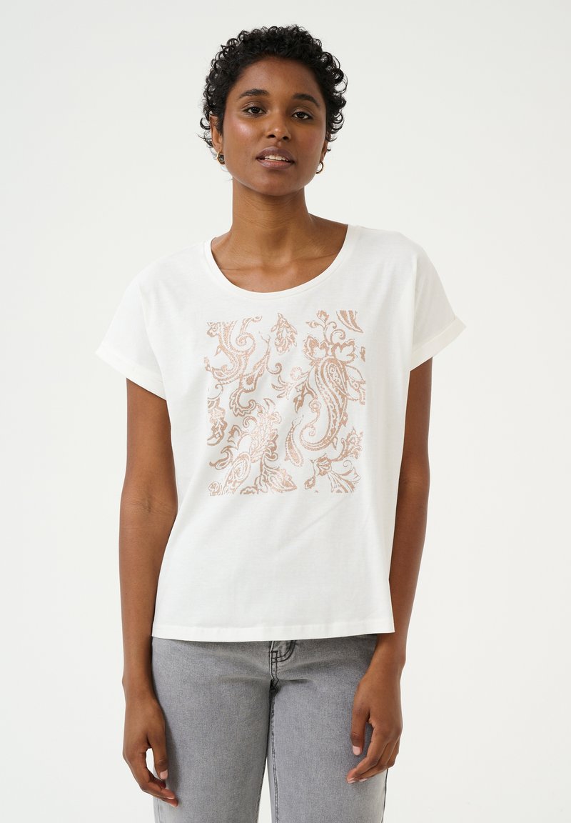 T-shirt blanc à manches courtes avec un col rond, présentant un design paisley doré rose métallique sur le devant. Tissu en coton, texture douce.
