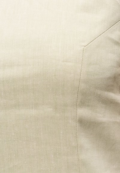 Υφασμάτινο σε ανοιχτό μπεζ με διακριτικό σχέδιο ψαροκόκκαλο και ραφή που τρέχει διαγώνια στη δεξιά πλευρά.