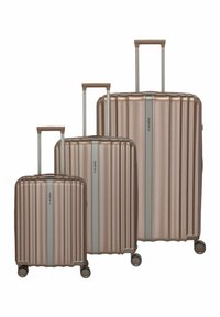 Trois valises métalliques bronze de tailles différentes, avec un design côtelé, des poignées extensibles et des roues à roulement fluide.