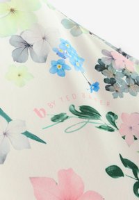 Tkanina s cvetličnim vzorcem v pastelnih odtenkih roza, modre in sive barve, z gladko teksturo. Logotip "b by Ted Baker" v mehki roza barvi.