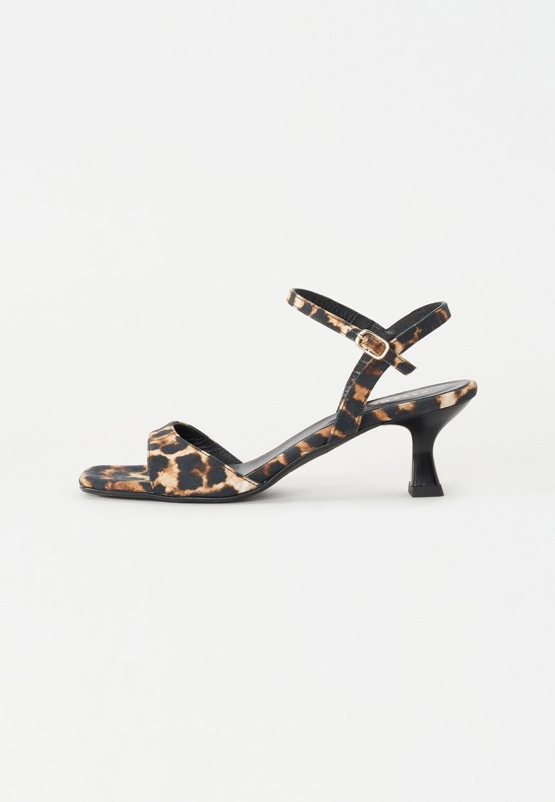 Sandale femme à bout ouvert avec des brides imprimé léopard, une petite boucle et un talon noir de hauteur moyenne sur fond blanc.