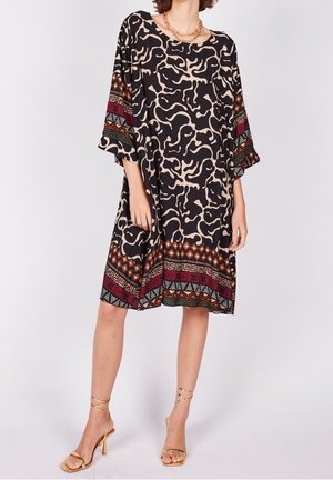 Robe noire ample avec un motif abstrait beige, manches évasées et un ourlet coloré avec des formes en rouge, vert et or.