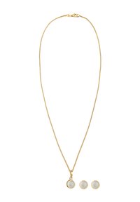 Halskette aus goldfarbenem Metall mit einem Anhänger, der zwei runde, weiße Steine zeigt; dazu passende Ohrstecker. Glatte, polierte Oberfläche.