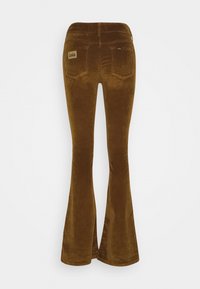 Pantalon évasé en velours côtelé marron avec poches arrière et une petite étiquette de marque en tissu sur la poche droite.