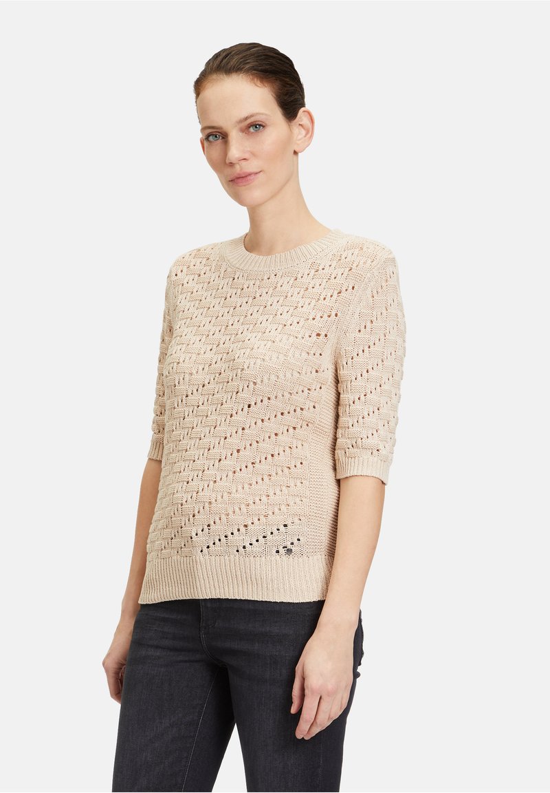 Beige Strickpullover mit strukturiertem Muster, kurzen Ärmeln und rundem Halsausschnitt. Verfügt über offene Maschen und einen gerippten Saum.
