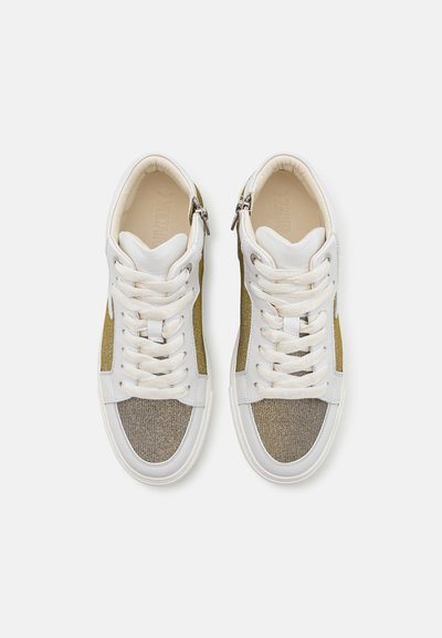 Witte sneakers met metallic gouden accenten, textuur grijs stof en een vlakke vetersluiting, met een ritsdetail aan de zijkant.