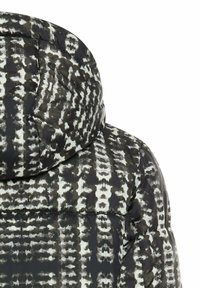 Puffermantel mit einem schwarz-weißen abstrakten Muster, der einen hohen Kragen und eine gesteppten Struktur für Isolierung bietet.