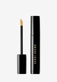Svart sylinderformet tube med gulltekst som leser "BOBBI BROWN." Festet applikator har en spiss, myk tupp for presisjon.