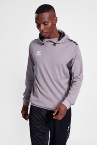 Felpa con cappuccio grigia, dotata di cordino e pannelli laterali neri, con logo sul petto; abbinata a pantaloni sportivi neri.