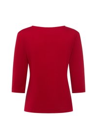 Maglietta rossa a maniche tre quarti con scollatura a barca. Il tessuto è liscio ed elasticizzato, con un design semplice privo di motivi o dettagli.