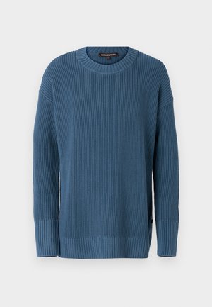 Blå strikket genser med rund hals, lange ermer og ribbestrikkede mansjetter og hem. Har et strukturert mønster og en logo-tag på siden.