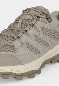 Μπεζ πεζοπορικό παπούτσι με πάνελ από δίχτυ, επενδύσεις από σουέτ, στρογγυλά κορδόνια και ανθεκτική ελαστική σόλα για πρόσφυση σε εξωτερικούς χώρους.