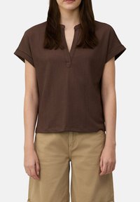BruineT-shirt met korte mouwen van een textuurstof, een V-hals en een ontspannen pasvorm. Gegoten met beige shorts.