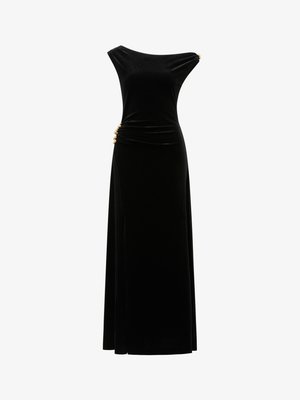 Svart fløyelskjole til kveld med tettsittende overdel, skulderløs utringning, rynking på siden og gullfargede pyntedetaljer i midjen. Lang, flytende skjørt.