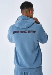 Sudadera de mezcla de algodón en azul claro con un gran logo "PXP" en oscuro en la parte posterior. Incluye un bolsillo tipo canguro en el frente y capucha ajustable con cordón.