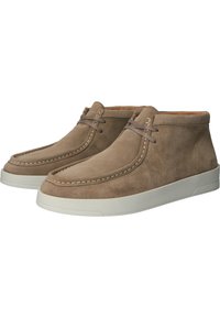 Bottes basses en daim marron avec semelles en caoutchouc blanc, présentant des détails cousus et des lacets plats, offrant un design épuré et minimaliste.