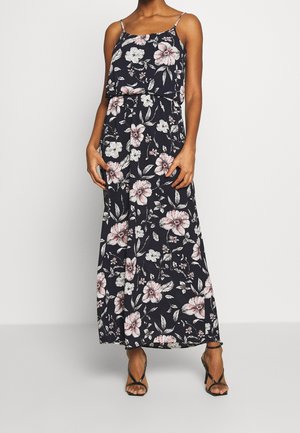 Robe maxi fleurie avec des bretelles spaghetti, présentant un fond bleu marine et des motifs floraux roses. Tissu léger et fluide avec une taille élastique.