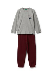 Maglietta grigia a maniche lunghe con collo rotondo e stampa grafica, abbinata a pantaloni elasticizzati bordeaux in vita. Materiale in cotone morbido, vestibilità casual.