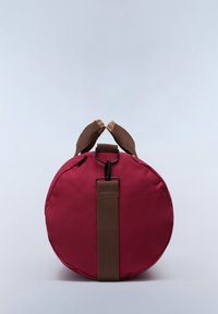 Borsa rotonda bordeaux con una texture liscia, dotata di manici intrecciati marroni e una tracolla removibile, e una clip nera per una chiusura sicura.