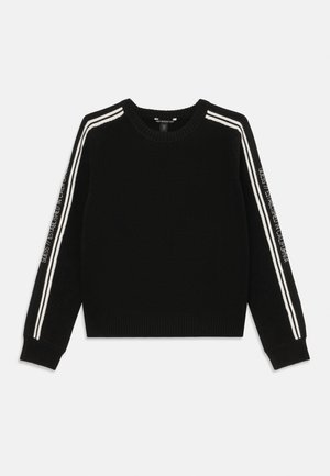 Melna adīta džemperis ar baltām svītrām uz pleciem un piedurknēm, ar teksta detaļu uz kreisās piedurknes. Apaļš kakla izgriezums, ribotas piedurknes un apakšējā mala.