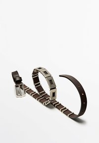 Tre cinture: una in pelle nera con fibbia metallica, una in pelle marrone con accenti rettangolari argentati e una sottile striscia in pelle marrone.