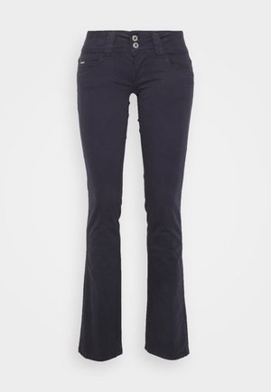Jeans azul marinho escuro, com corte flare e uma textura suave, dois bolsos frontais, fecho de dois botões e um discreto logotipo da marca perto da cintura.