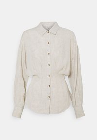 Chemise en lin beige clair à boutons, avec un col pointu, des manches longues et un ourlet arrondi ; accentuée par des boutons marron.
