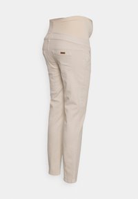 Calças de maternidade bege com um cós elástico, design de cinco bolsos e perna afunilada. Feitas de um tecido suave e confortável.