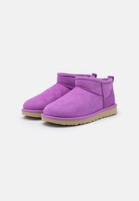 Bottines en daim violet avec un bout arrondi, une tige courte et une semelle en caoutchouc beige. Caractérisées par un motif cousu et une languette à l'arrière.