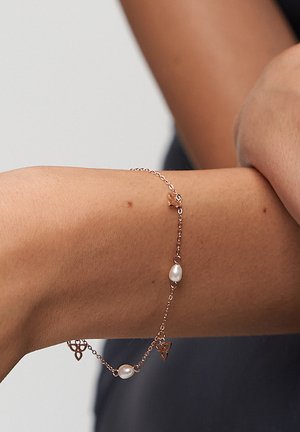 Rose gold bracelet featuring a delicate chain, pearl accents, and small butterfly-shaped links. Smooth texture and minimalist design.