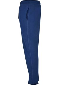 Pantaloni de trening bleumarin cu buzunare laterale, talie elastică și picioare conice. Realizați dintr-un material moale cu o textură netedă.