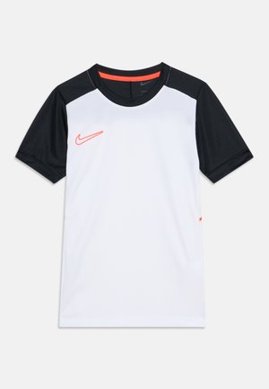 Športové tričko s krátkym rukávom s bielym telom, čiernymi rukávmi, čiernym golierom a červeným logom Nike na ľavej strane hrudníka.