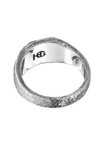 Silverring med en texturerad, ojämn yta. Polerad innerband med ingraverade initialer. Rund form, subtila variationer i ytbehandling.