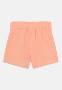 Bermudas de color melocotón con cintura elástica, tela ligera y textura suave. Presentan un diseño holgado y un dobladillo recto.