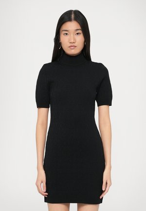 Czarna dzianinowa sukienka z wysokim kołnierzem, krótkimi rękawami i dopasowanym krojem. Całość zdobi teksturowany wzór na tkaninie.