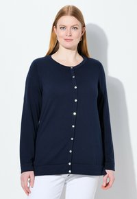 Námořnický cardigan s dlouhým rukávem, kulatým výstřihem, předním zapínáním na kovové knoflíky, měkkou texturou a uvolněným střihem.