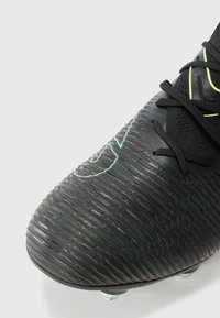 Cizma de fotbal neagră cu texturi groase, accente neon verzi și un design structurat, cu un branding proeminent și cu spike-uri modelate.