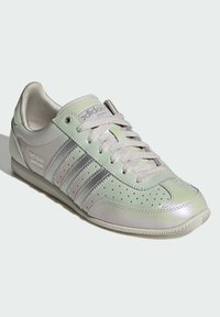 Gaiši zaļš ādas sneikera apavs ar sudraba akcentiem, ar šņorēm, sānos perforētiem akcentiem un teksturētu zolīti.