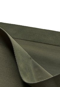 Tessuto verde oliva con una superficie morbida e texturizzata e un retro liscio, con un bordo piegato che rivela strati di diversi materiali.