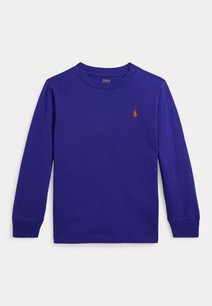 Chemise à manches longues en coton violet vif. Col rond avec poignets côtelés. Présente un petit logo rouge brodé sur le côté gauche de la poitrine.