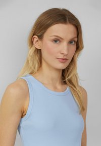 Lichtblauw geribbeld tanktop met een ronde halslijn en een semi-fitting ontwerp, met schouderbanden en een gladde textuur.