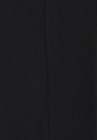 Tela negra con una textura suave, que presenta un detalle sutil de una costura vertical. El diseño es minimalista y carece de patrones o acentos.