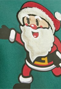 Groene stof met een cartoon Santa met een fluffy witte baard, rode hoed en outfit, zwarte handschoenen en een gele riem, in een speelse pose.