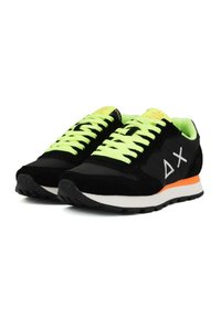 Scarpe sportive nere e grigie con lacci verde neon, accenti arancioni e una tomaia in suede e rete testurizzata. Presentano un sottopiede bianco e una suola pattern.