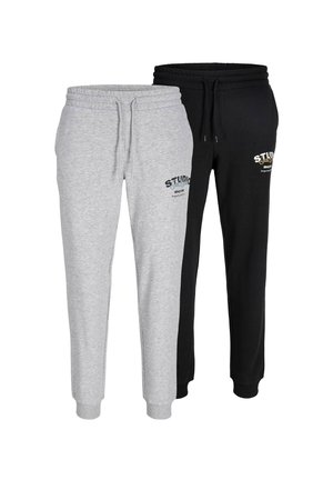 Zwei Paare Jogginghosen: eine graue mit Kordelzug und Logo, eine schwarze mit Kordelzug und kontrastierendem Logo. Beide besitzen elastische Bündchen.