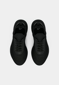 Μαύρα αθλητικά παπούτσια με υφασμένο επάνω μέρος και λαστιχένια σόλα. Διαθέτουν σχέδιο με κορδόνια και το λογότυπο Ortholite Float στις εσωτερικές σόλες.